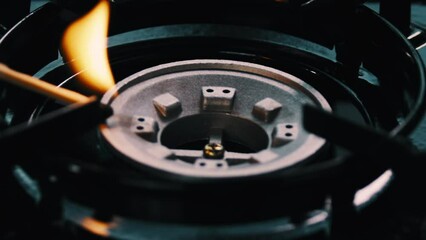 Match lighting a fire on a gas stove top - Powered by Adobe