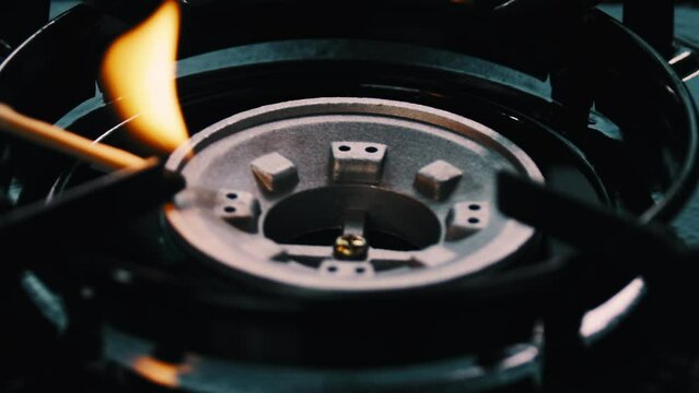 Match lighting a fire on a gas stove top