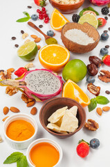 Assorted fresh fruits and nuts on a white background. Ingredients for a healthy dish