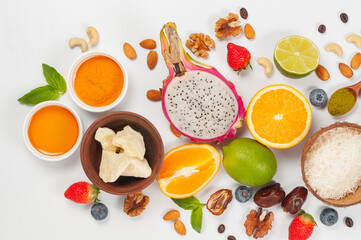 Assorted fresh fruits and nuts on a white background. Ingredients for a healthy dish
