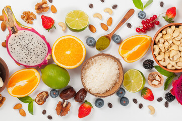 Assorted fresh fruits and nuts on a white background. Ingredients for a healthy dish