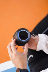 Man Pressing Button Volume On Wireless Speaker Bluetooth Gadget On Basketball Court
