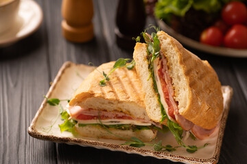 Delicious hot sandwiches are served on a white plate in a restaurant on the table. Traditional...