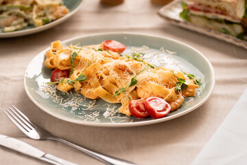 Fettuccine pasta with shrimp, tomatoes and herbs serving on plate, top view. Italian food concept.