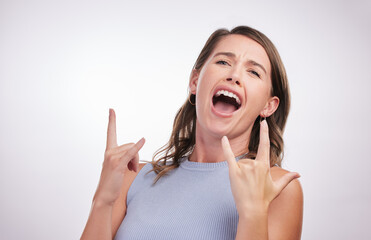 Rock, hand and gesture with woman for celebration in studio or confidence for success, achievement and freedom of expression. Happy, excited and person with sign for creative heavy metal or music