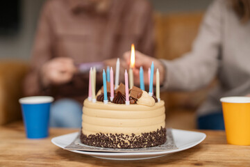 Family celebrating birthday party, lighting candles on cake.  Lifestyle people.