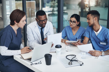 Doctors, teamwork and planning for healthcare in office with laptop, documents and research. Nurses, collaboration and group diversity in boardroom brainstorming strategy for telemedicine development