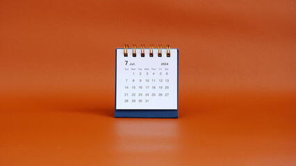 Desk calendar for Junly 2024 on a red background with copy space.