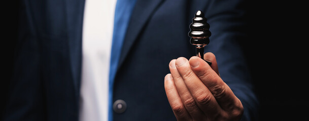 metal butt plug in a man's hand. The concept of anal sex. Wide horizontal banner header