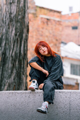Korean woman exhibiting urban style, resting with red hair, in a cityscape