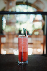 Strawberry cocktail in a tall glass with bokeh background