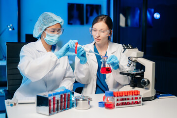 Modern Medical Research Laboratory Portrait of Two Scientists Working, Using Digital Tablet,...