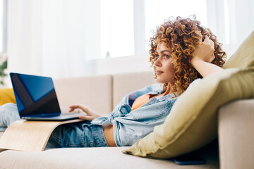Smiling Woman Typing on Laptop in Cozy Living Room, Enjoying Freelance Online Work