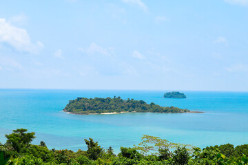 An island in the middle of the sea with blue water and green trees, a beauty created by nature.