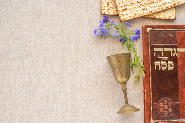 Jewish holiday Pesach (Passover) celebration concept. Traditional book with text in Hebrew:...