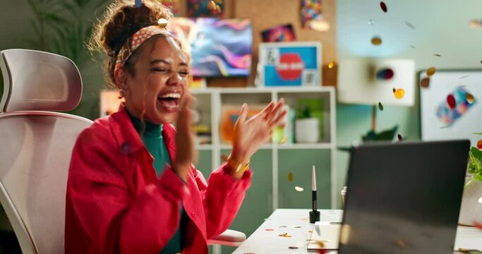Happy woman, laptop and celebration with confetti at office for winning, promotion or prize. Excited female person with fist pump in joy for amazing deal, promo or lottery winner on computer at desk