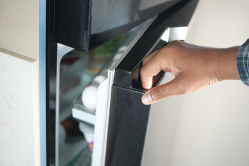 half open fridge with food and vegetables ,