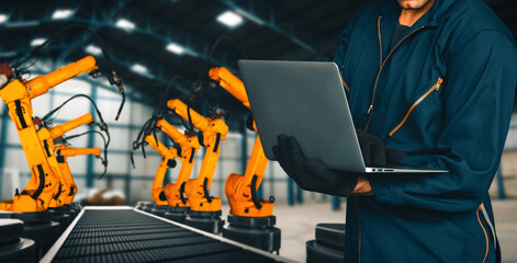 MLP Engineer use advanced robotic software to control industry robot arm in factory. Automation...