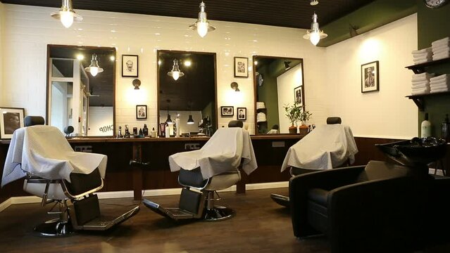 Interior of a modern barbershop room with three working places. Stylish hair studio indoors. 