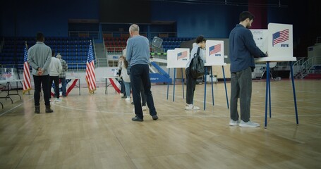 Vote here sign on the floor. Queue of multi ethnic American citizens come to vote in polling...