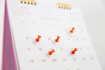 Red pin on blank desk calendar in office workplace concept time management event planner or...