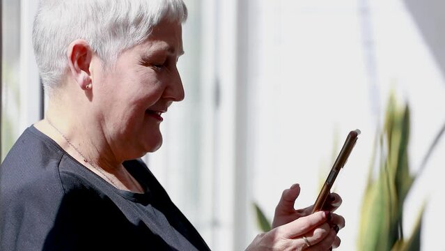 mujer mature senior chateando rapido en el telefono movil