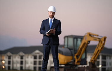 Worker in suit and helmet. Investor civil engineer, construction manager. Construction building developer at a construction site. Successful architect. Handsome hispanic builder man in suit.