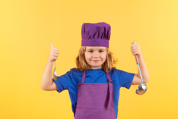 Funny kid chef cook with kitchen ladle, studio portrait. Kid in cooker uniform and chef hat...