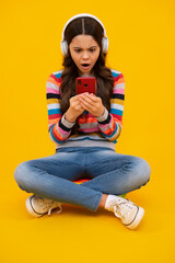 Teenage girl with smart phone. Portrait of teen child using mobile phone, cell web app. Shocked amazed face, surprised emotions of young teenager girl.