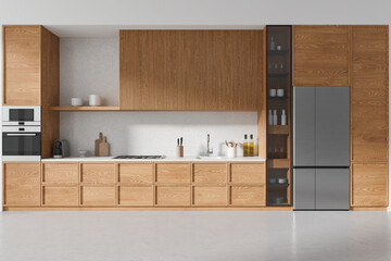 Modern home kitchen interior with cooking space, kitchenware and fridge