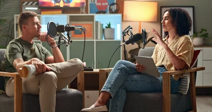 Happy people, interview and podcast with tablet or influencer in meeting, discussion or talk show at studio. Man and woman speaking on air together with mic for communication, live chat or recording