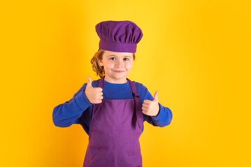 Cooking children. Chef kid boy making healthy food. Portrait of little child in chef hat isolated on studio background. Kid chef. Cooking process.