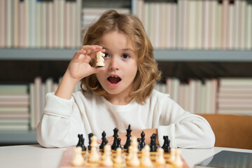 Smart kid playing chess. Clever child thinking about chess.