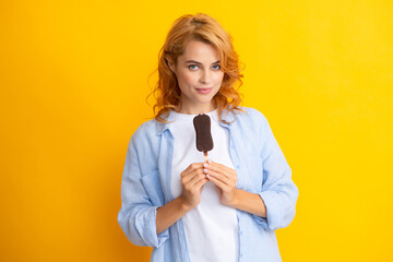 Girl posing with chocolate ice cream on yellow isolated background. Summer woman.