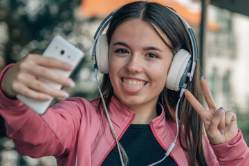 teen girl wearing headphones and making ok gesture