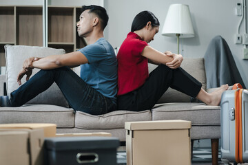 Unhappy young couple sitting apart, having problems in relationship, thinking of breaking up or...