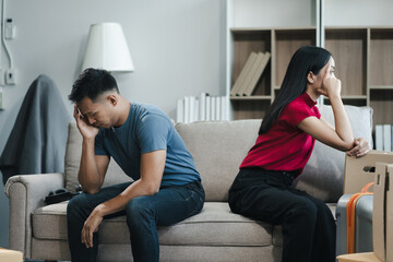 Unhappy young couple sitting apart, having problems in relationship, thinking of breaking up or...