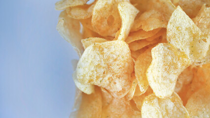 Close up crisp yellow potato chips over a plain background, still life, deep fried, healthy, snack,...