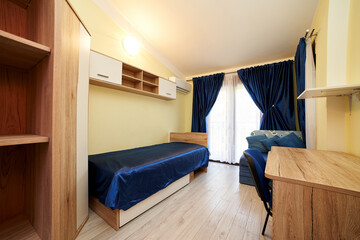 Single hotel room with bed, desk and wardrobe