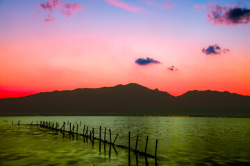 Kwan Phayao Lake with the silhouette of the mountain range at sunset in Phayao Province