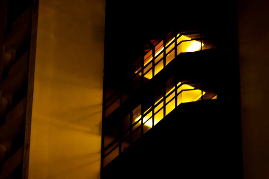 A building with a staircase that is lit up in the dark. The staircase is lit up with yellow lights, which creates a warm and inviting atmosphere