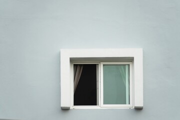 A window with a white frame and a white curtain