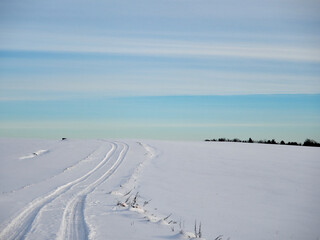 Winter evening landscape. Winter field and road in the snow. Snow and sky