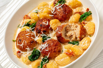 tuscan chicken meatballs with gnocchi in a bowl