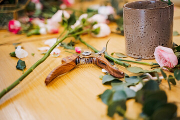 Pair of scissors on wooden table with flower vase for event garnish