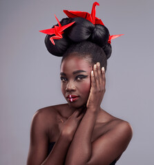 Black woman, studio and portrait with origami for beauty, traditional or creative with cosmetics....
