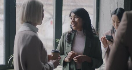 Seminar participants talking drinking take away coffee and using smartphones during break in business hall. Communication and people concept. - Powered by Adobe