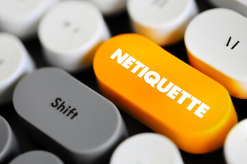 Netiquette is a set of rules that encourages appropriate and courteous online behavior, text concept button on keyboard - 797585168