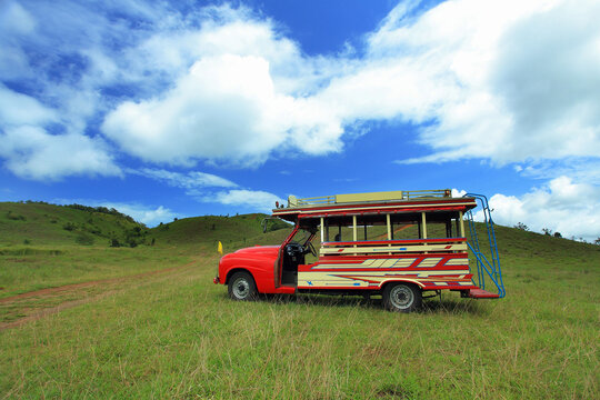 Wooden minibus in green grass mountain in rainy season at ranong province, southern Thailand 