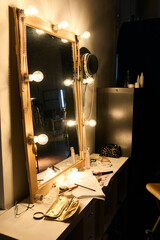 Vertical background image of vanity table with warm lamplight backstage no people